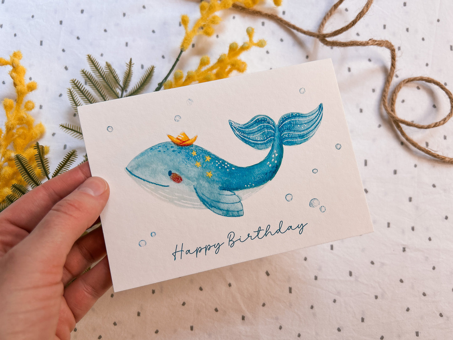 Held in a hand / product usage shot with Happy whale birthday card with cute ocean animal illustration, A6 greeting card